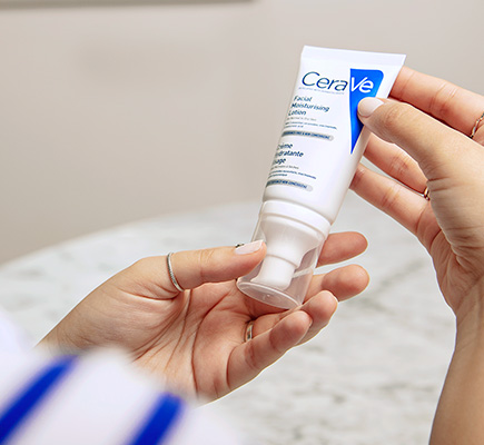 Frau hält die CeraVe Feuchtigkeitscreme für das Gesicht in ihren Händen